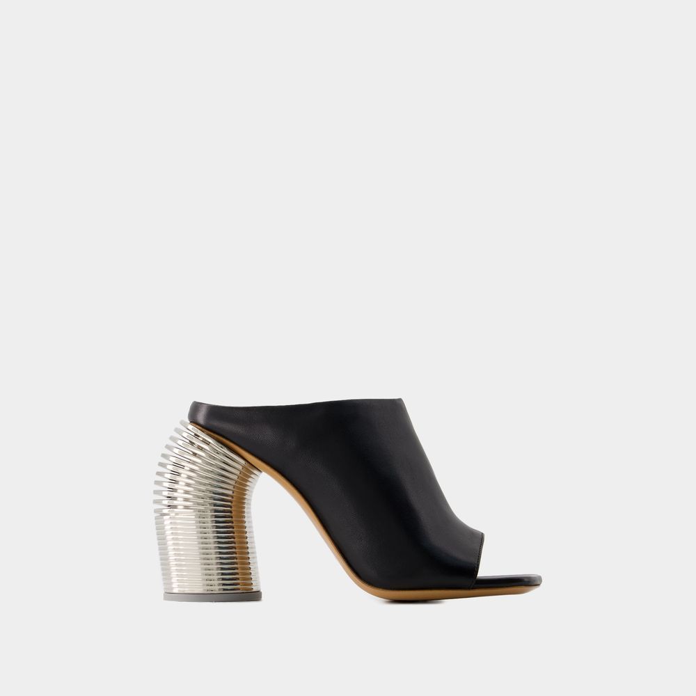 Skulpturale Mules mit Federabsatz