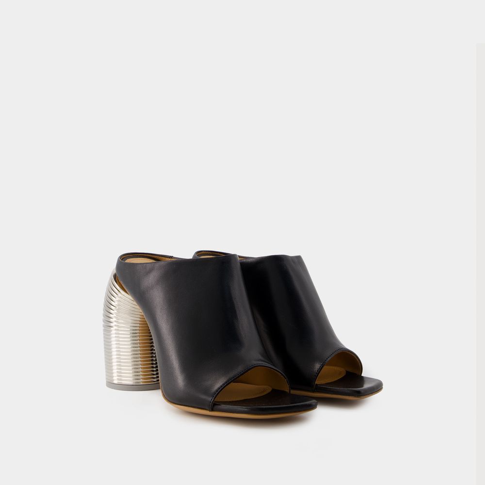 Skulpturale Mules mit Federabsatz